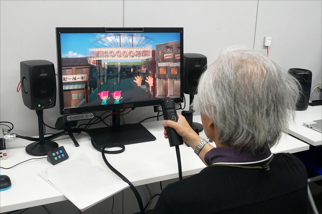 画像: 体感リモコンを使ってデモを体験する麻倉さん