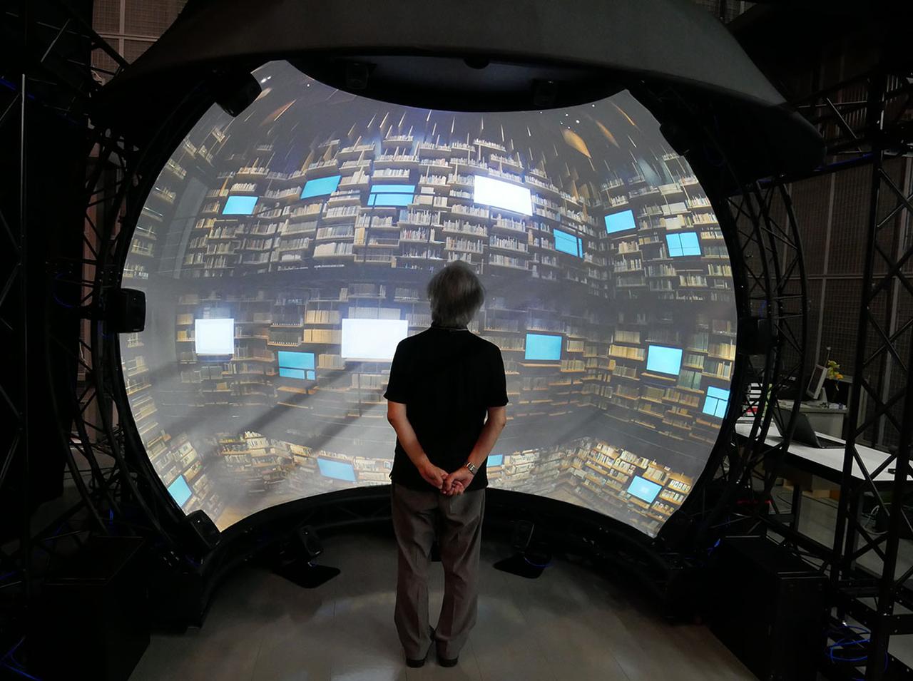 画像: 半球状表示装置を体験する麻倉さん。1.5m弱の視聴距離から見ると、かなりの迫力です