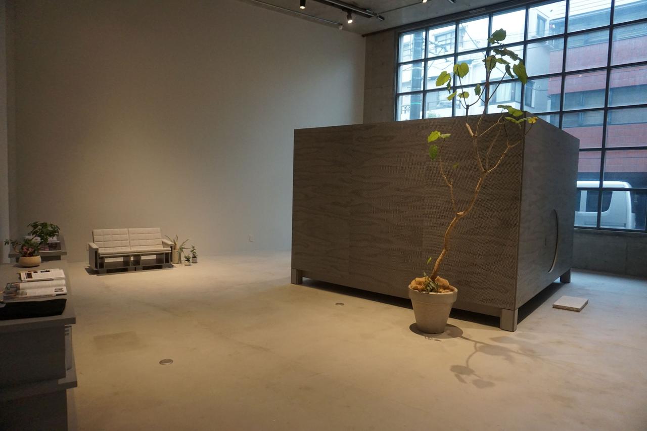 画像: フロアの中心には「サウンドハウス」と名付けられた小建築が設置されており、空間内に置かれた一つの彫刻作品のような存在感を放っている。「サウンドハウス」の周囲には、Devon氏の音響哲学が綴られた書籍と椅子が配され、来場者は「聞く」「読む」「座る」という一連の行為を通じて、同氏が描き出す深く瞑想的な世界観を堪能できる