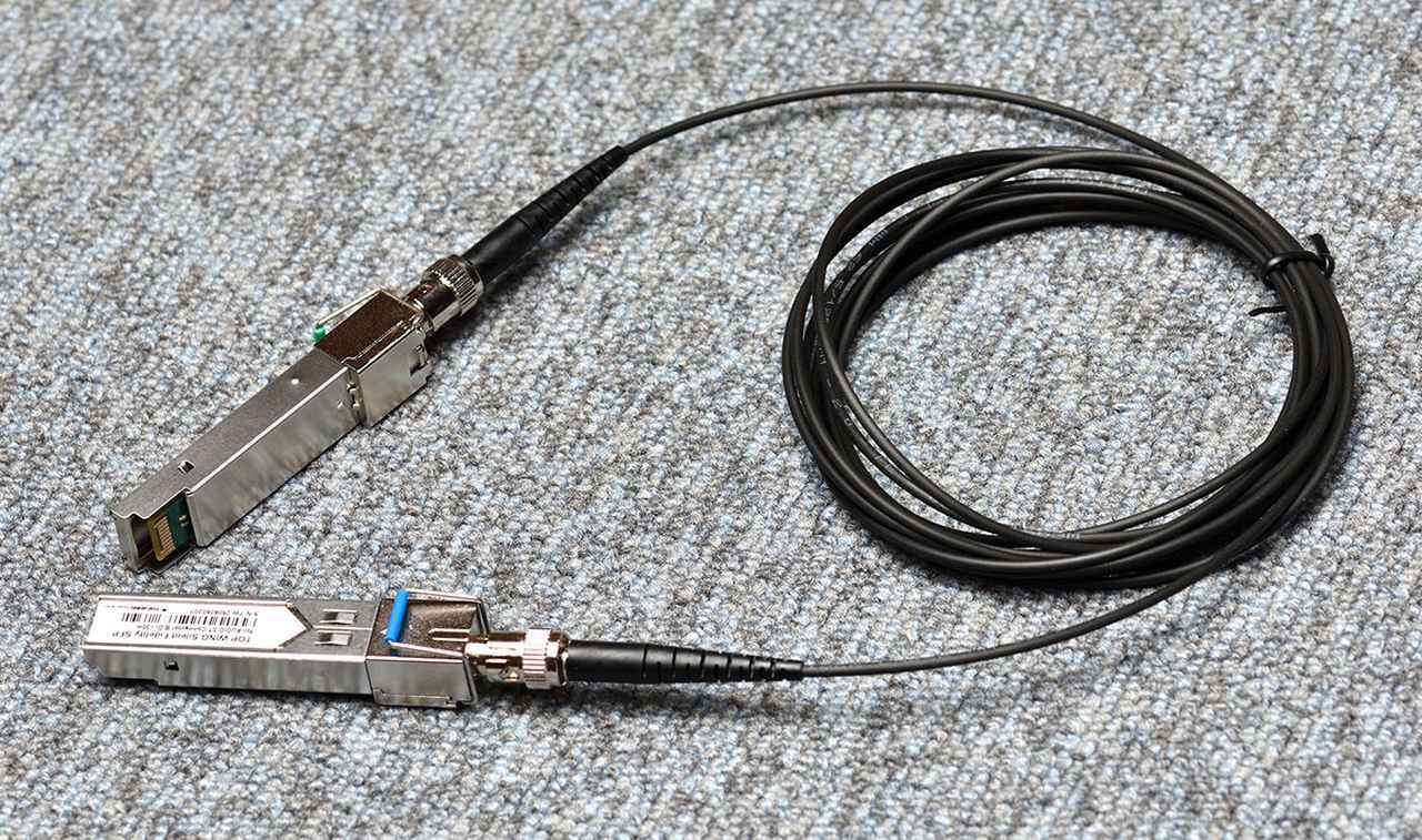 画像: 「Silent Fidelity SFP」は、写真左側の金属部部のモジュールで電気信号を光信号に変換・復元して伝送する仕組み。SFPモジュールと3mの付属専用ケーブルはSTコネクターで安定した接続を実現している