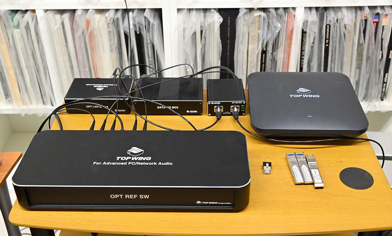 画像: ネットワークハブ「OPT REF SW」（写真手前）を中心に、多くのトップウイング製品を使用したシステムが組まれている。写真右後方はオーディオ再生用の無線ルーター「OPT AP」で、OPT REF SWとの間はSPFケーブル「Silent Fiderity SFP」でつないでいる