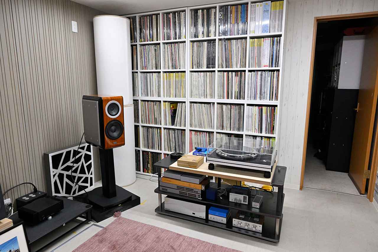 画像: 低音がこもらないように、部屋の角には大型の吸音材を設置。写真右側のドアも低域の調整のために、音を聴く時はあえて開けている。隣がカラオケ教室なので、心配なく音を出せるという理想的な環境です。壁面に並んでいるアナログレコードは菅沼さんのコレクションとか