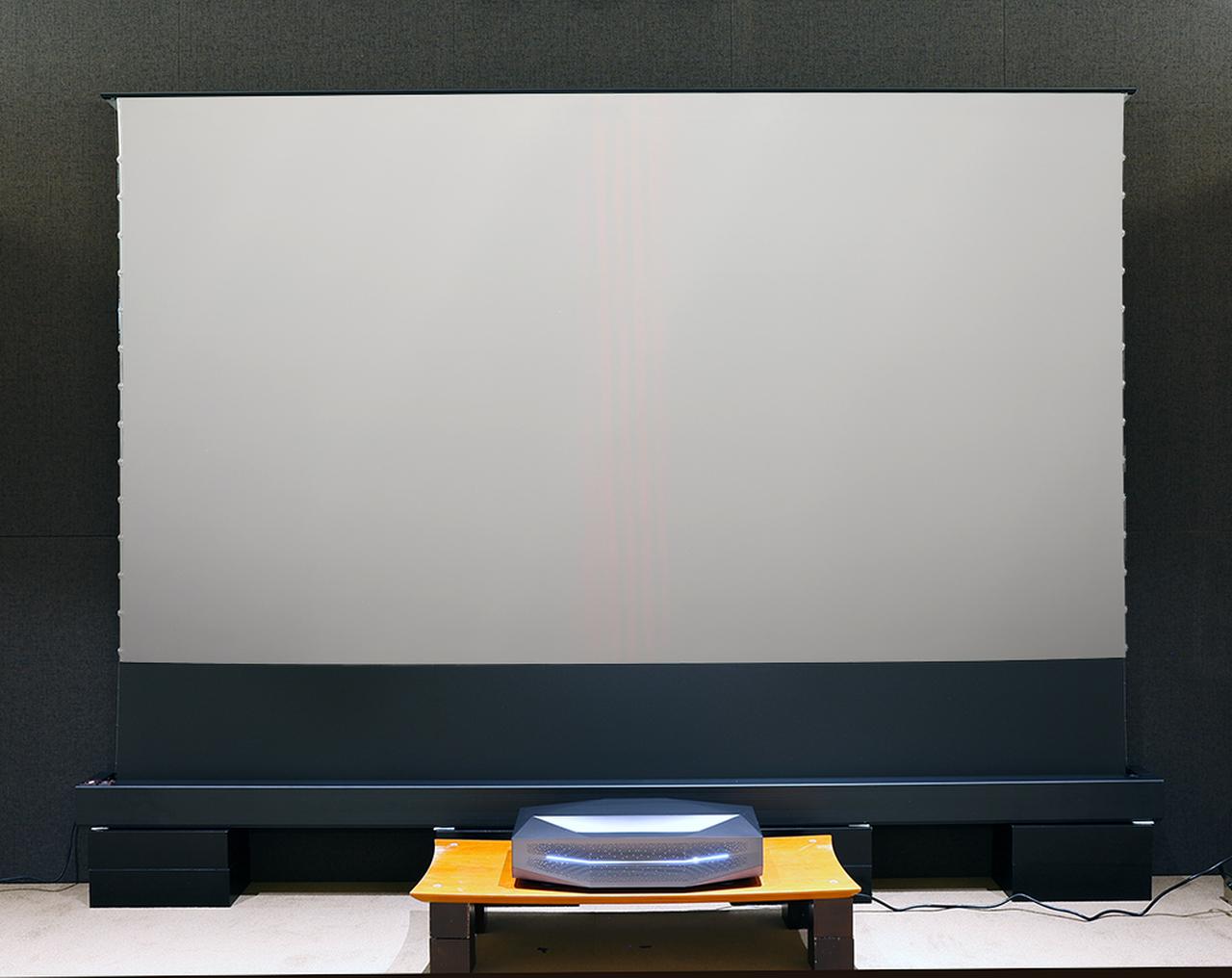 画像: ▲今回のレビューでは、床置きの120インチ電動ALRスクリーンを組み合わせて視聴した。Aetherionの電源に連動して自動でスクリーンが立ち上がってくるので便利。幕面はシルバーコートされていて、輝度を高く取れるのも特徴