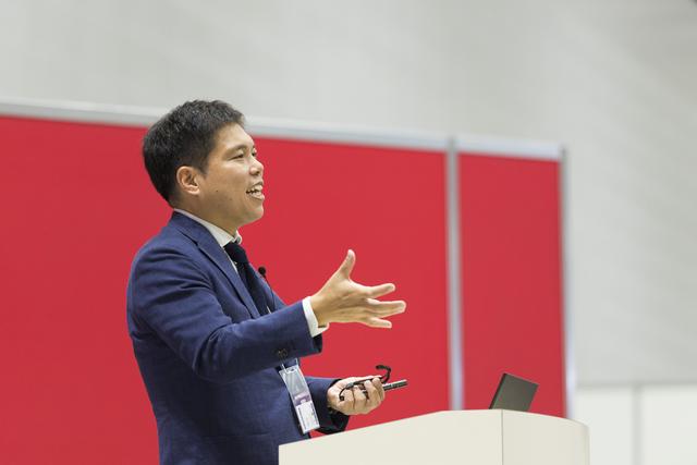 画像: ステージでプレゼンテーションする事業推進役員の加藤氏