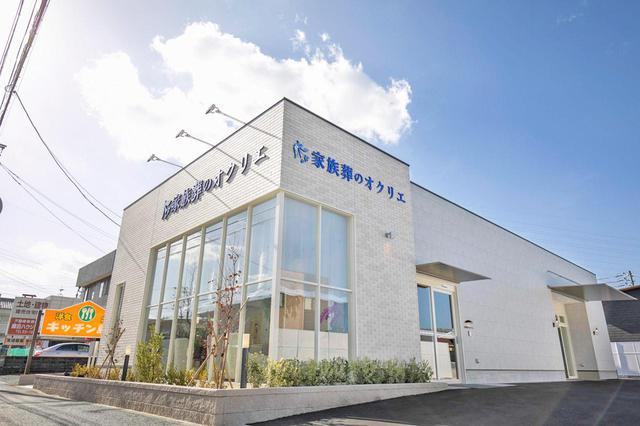 画像: 道路に面した部分には、大きな窓のある事前相談室。 入り口は、建物横にある。もうひとつ奥の扉は出棺時に使用する