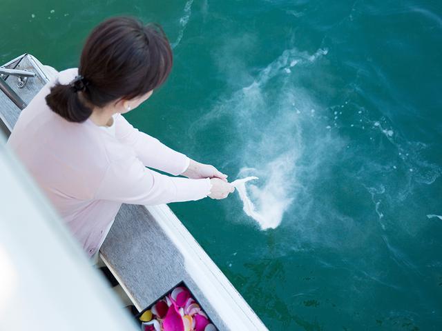 画像: 散骨場所に着いたら、参列者が順に、お骨を海に還していく