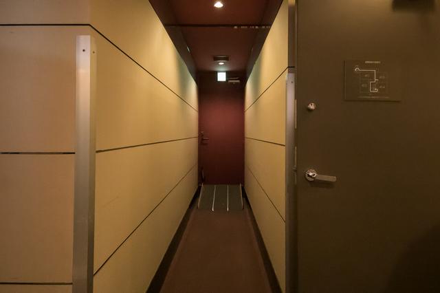画像: 非常口に向かって、建物内部から見たところ。 廊下の角は、ストレッチャーがぶつかっても大丈夫なように補強されている