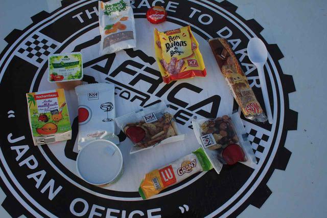 画像: これが毎日配布されるランチパックの中身。ナッツ類、スナック菓子やゼリー、パック入りのジュース、サラミソーセージにチーズなど。それに飲料数もくれる。いろいろな味を楽しめるのがいい