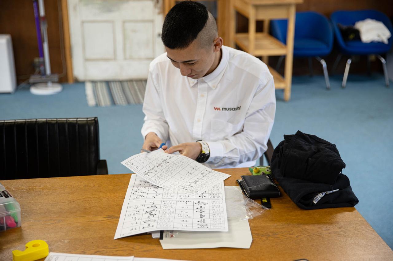 画像: 合宿はコマ図をハサミで切って繋げ、長いロールにするところから。本番はロールのコマ図が配られる