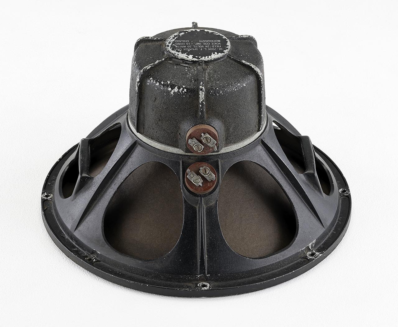 画像: 18インチウーファーSE7034は1938年に登場したミラフォニック・サウンドシステムM7を構成するSE7508スピーカーシステムに採用されたユニットで、フィールド電圧24V／1Aという仕様。組み合わせたパワーサプライはタンガーバルブ4B-28を2本使用したSE7520電源で、24V／1AをそれぞれのSE7034に供給している。また、SE7520はミラフォニック・サウンドシステムM10、M10 Dualなどで使用されたパワーアンプTA7467A（300A・pp、出力15W）と同じ金属ケースに納められている。（土井）