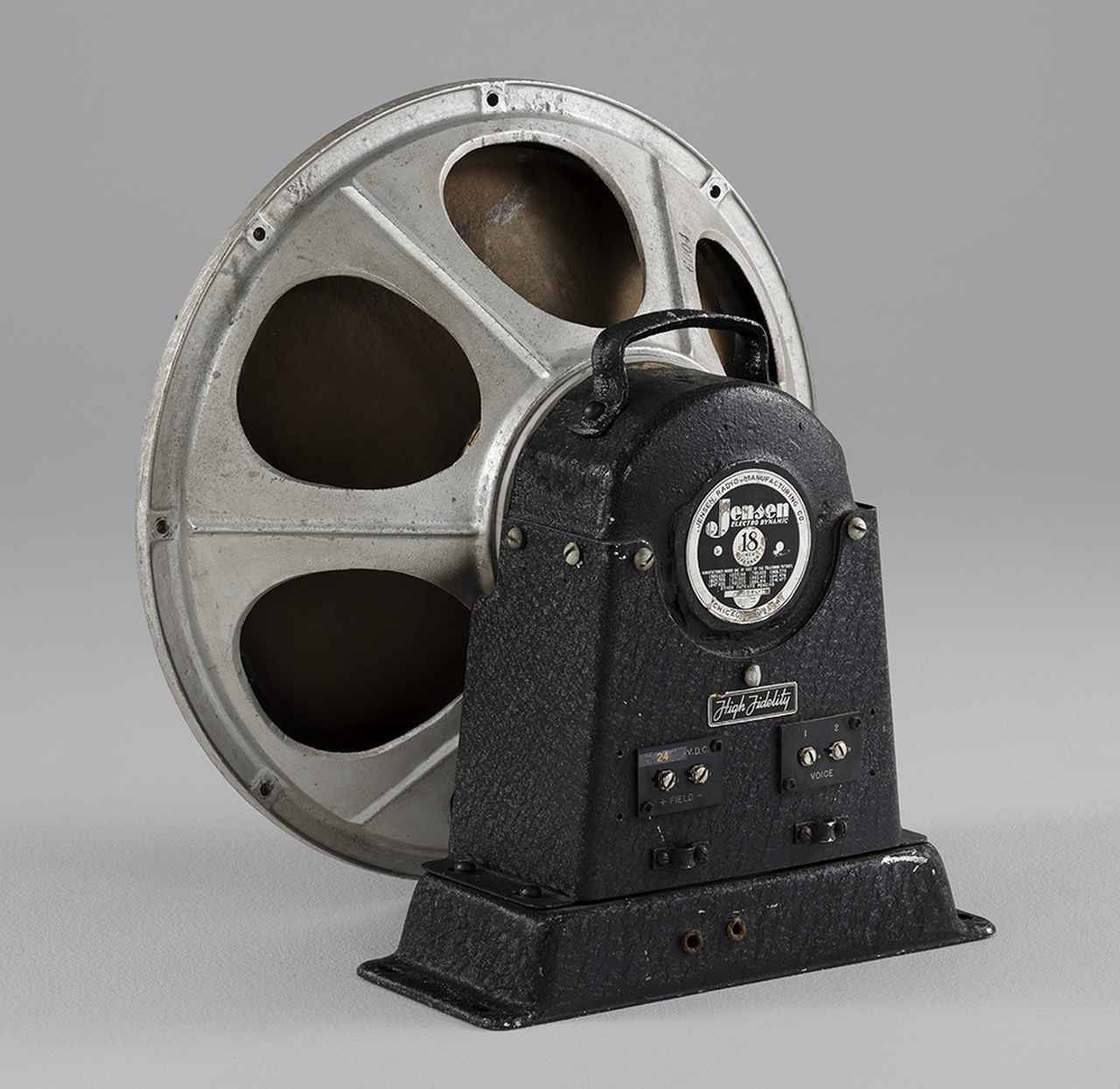 画像: ジェンセンのフィールド型18インチにはL／M／HFの3タイプがあり、Lは低域用、Mはミュージック、HFは全帯域用という意味のようだ。本機HFはコーンのセンター部にアルミ素材が使用されていて、中程から紙製のコーンが継がれている。またアルミコーン部の色はブルーとアルミ色の2色が存在する。本機のフィールド電圧は24V仕様となっており、試聴ではSE7034と同じタンガー電源SE7520を使用した。（土井）