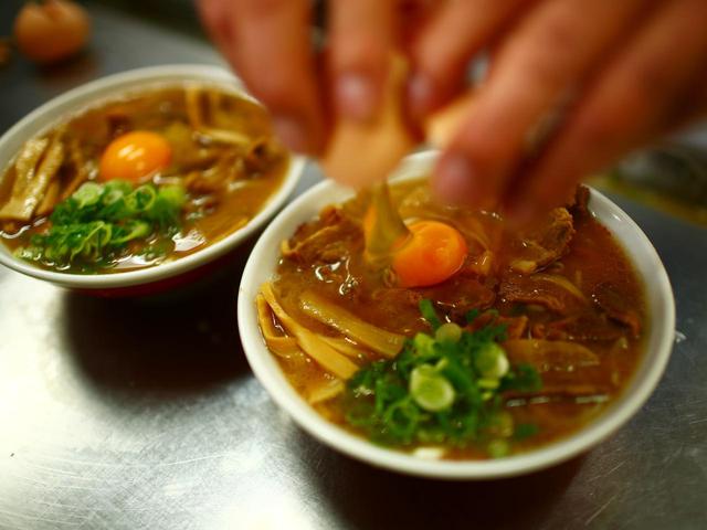 画像: とんこつ醤油の甘辛いスープに濃い味付けで煮込んだ豚肉のコクが生卵でつなぎ合わされる