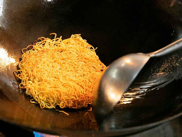 画像: たまご麺の極細麺を蒸して一晩寝かせ、茹でた後に水気を飛ばす。両面をこんがり焼き上げ、正面はパリッと、中はフワッと仕上げる