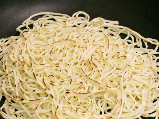 画像: 絶妙の加減で焼かれた麺は石焼鍋に移され、おこげのような香ばしい味わいに