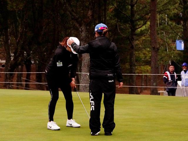 画像: 2日目のラウンド後、キャディとともにパット矯正に取り組む渋野。青木コーチのアドバイスが"しぶこチャージ"につながった