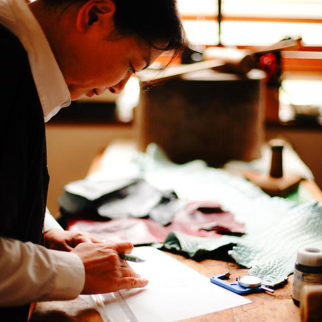 画像: 革の厚さや風合いをチェックしながら、デザインを考えていく。使用する川は色の調合から検討し、オリジナルの色に染色を依頼