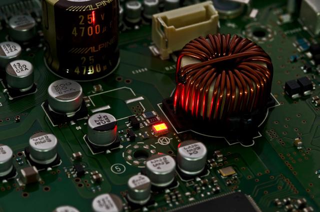 画像: 回路基板上に光るインジケータではなく、赤色LED(発光ダイオード)の性質を活用した電源回路を、本機でも導入。ノイズの低減、特に低音部を最大40dBも低減させることができたとのこと。