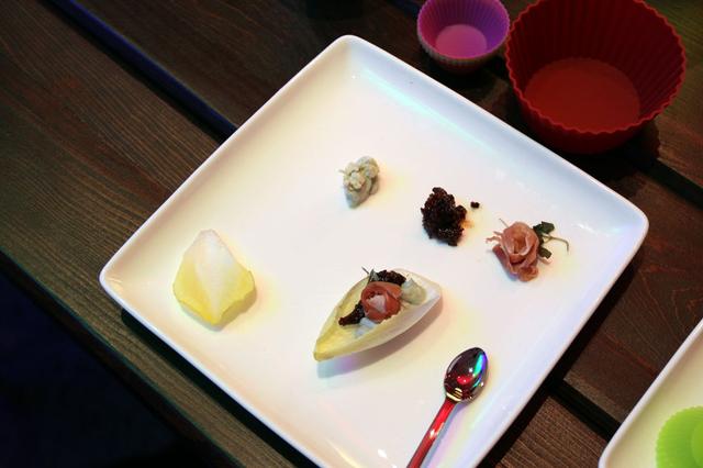 画像: こちらは、音楽を構成する音のバランスを料理の味にたとえて紹介したもの。皿の中央に各食材が一緒になったチコリポートが置かれ、その周りに食材が並ぶ。チコリポートを構成する食材それぞれを食べると塩味や甘みが強すぎたりするが。合わせた調理を食べると絶妙な味わいとなる。音楽もこれと同じというわけだ。