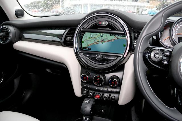 画像: MINI独特のセンターコンソールデザイン。8.8インチのワイドディスプレイを縁取る円形のベゼルにはLEDイルミネーションが備わっており、インフォテインメントシステムの操作に応じて様々なカラーリングでインテリアを彩る。