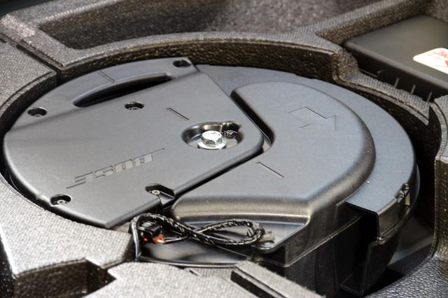 画像: サブウーファーを車室内側から見ると、低音を送出するポートが確認できる。トップパネルにはBOSEのロゴと、ユニットの固定向きを示す矢印が見える。