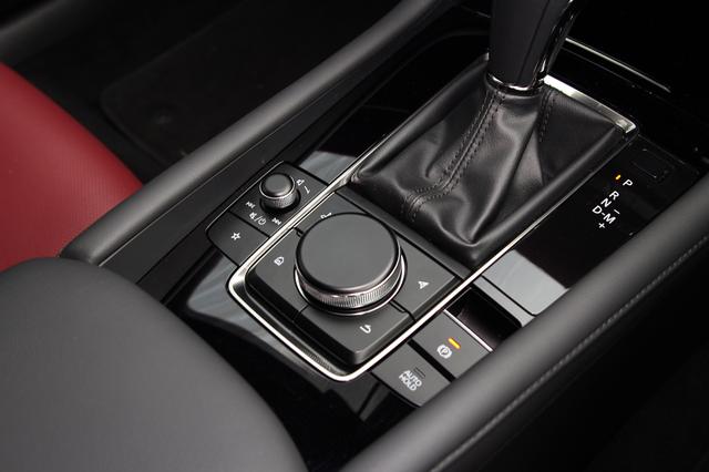 画像: シフトノブの後方には、マツダコネクトのコントローラースイッチが並ぶ。中央のダイヤルは回す/押す/ずらすで操作できるほか、天面がタッチパッドになっていて、ナビ地図画面の拡大縮小などの操作ができる。