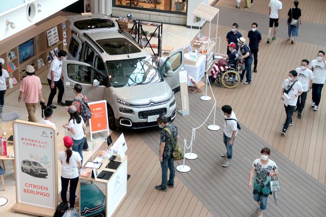 画像: ららぽーと豊洲のセンターエントランスに設けられた展示ブース。車両横にはノベルティ販売ワゴンも置かれている。