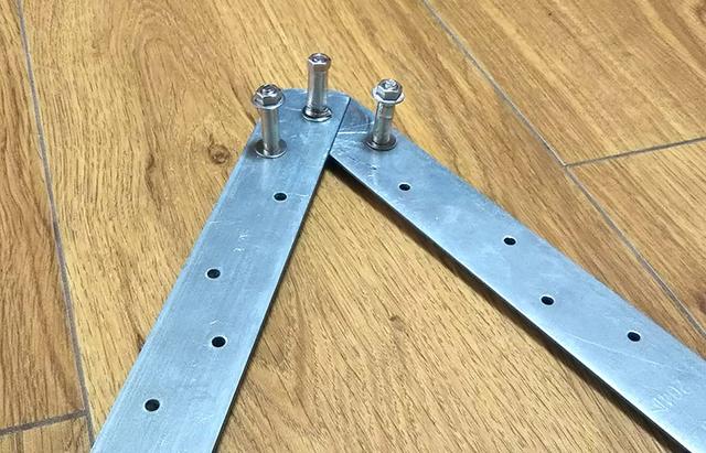 画像: 筆者撮影 棒を曲げるための自作治具「穴のあいた金属板とボルトとナットで作った簡単な治具」