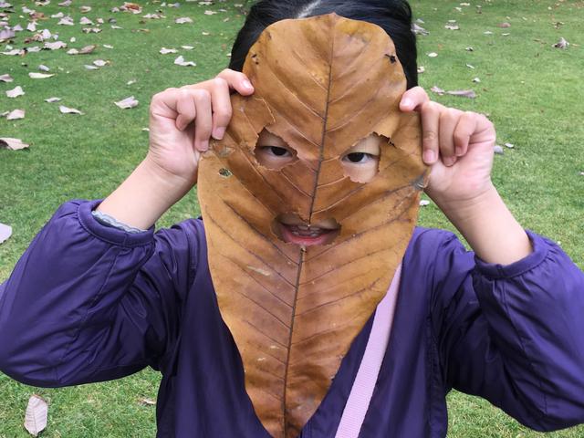 画像: 筆者撮影 ホオノキの葉でお面を作成する子供(北海道知事公館)