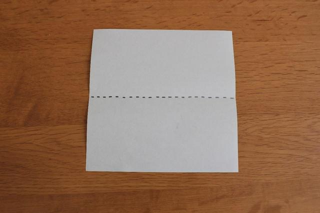 画像: 1.裏側をテーブルに置いて点線で上から半分に折る (筆者撮影)