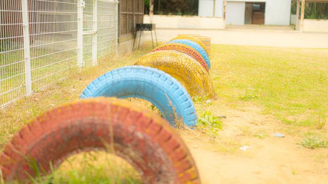 画像: 校庭の隅にあるタイヤの遊び場。 campeena.com