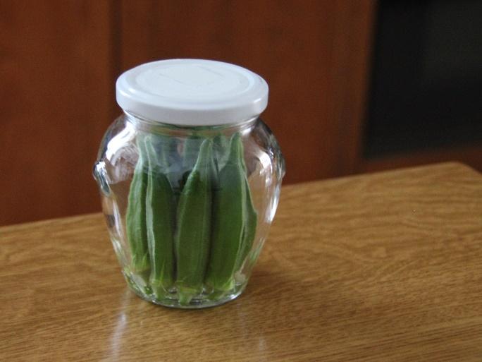 画像: 少量の水をはった瓶にオクラを立てて入れる (筆者撮影)