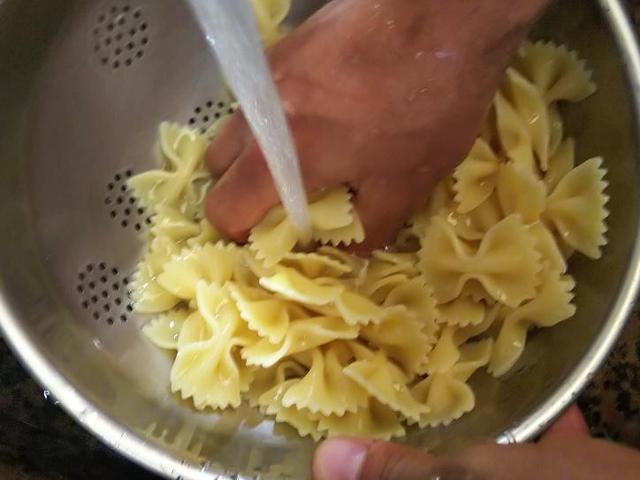 画像: 手順5.茹で上がったパスタを流水で冷やす (筆者撮影)