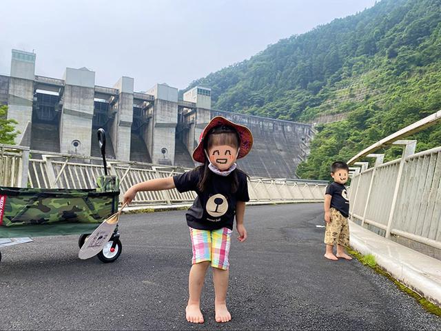 画像: 筆者撮影 日吉ダムをバックに満面の笑みの娘でした
