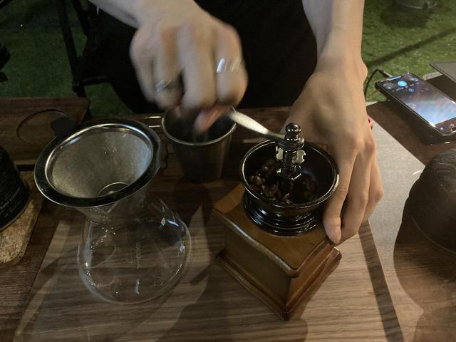 画像: 豆挽き初体験の筆者 (筆者撮影)