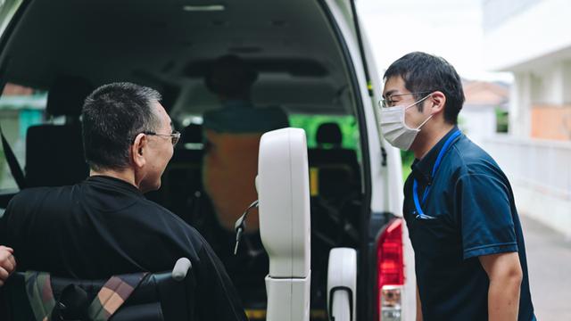 画像: 利用者を見送る丸山さん。「気楽に頼られる存在になりたい」と話す
