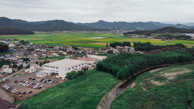 画像: 陽光園のすぐそばを旗川は流れる。左手前の白い建物が愛光園のクリーニング工場