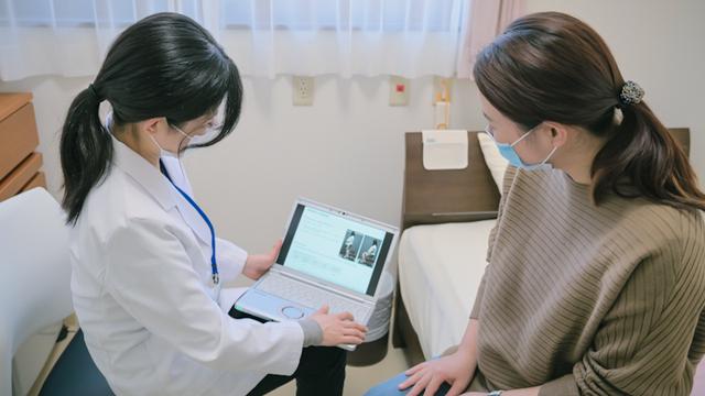 画像: 腰痛のメカニズムを妊婦に解説する森野さん