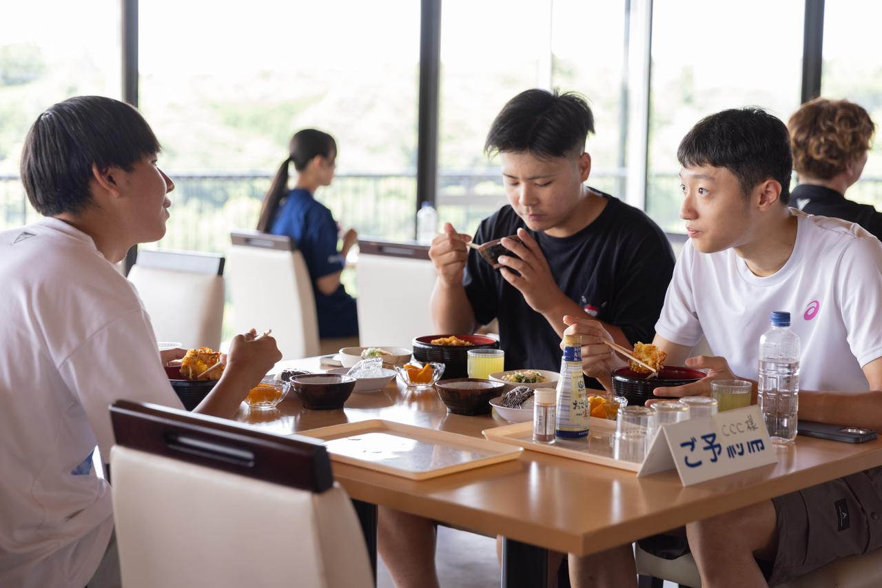 画像: 食堂でランチを食べる参加選手。言語の違いを超えて親睦を深めます