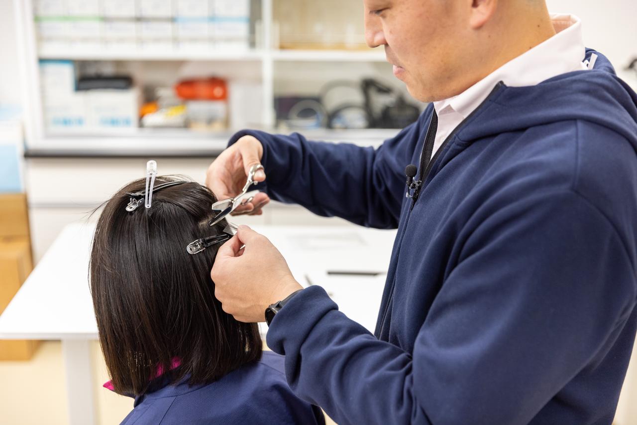 画像: 慣れた手つきで毛髪を採取する越智先生