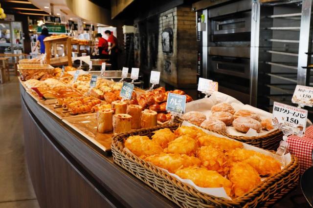 画像: 様々な種類の焼き立てパンが並ぶパン工房