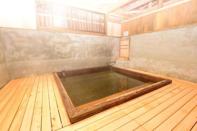 画像: 湯船がひとつあるだけの素朴な浴場。コンクリートを溶かす強酸泉であるため、湯船と床には松と桧が使用されている