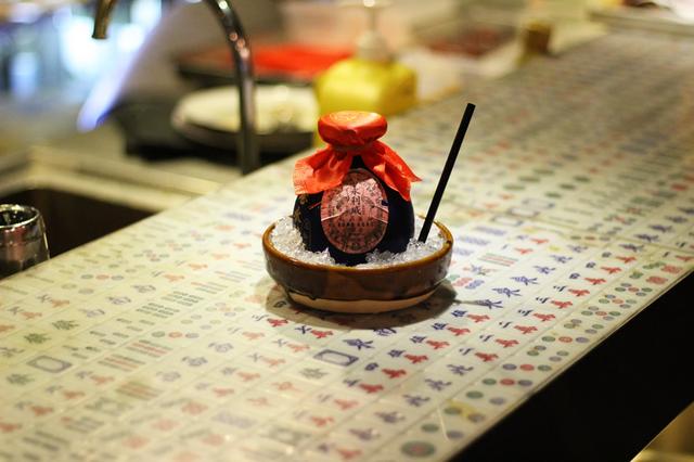 画像: 五加皮酒をベースにした「“Dong Ning Cha” 128」。古酒のカメのような器と、麻雀牌を敷き詰めたカウンターで、中華スタイルへのこだわりを感じさせる
