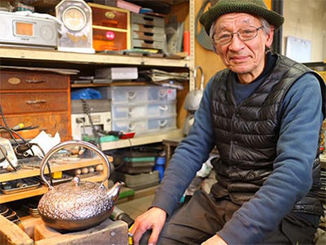 画像: お話を伺った南部鉄器伝統工芸士会会長でもいらっしゃる田山和康さん 左下にあるのは砂鉄の鉄瓶
