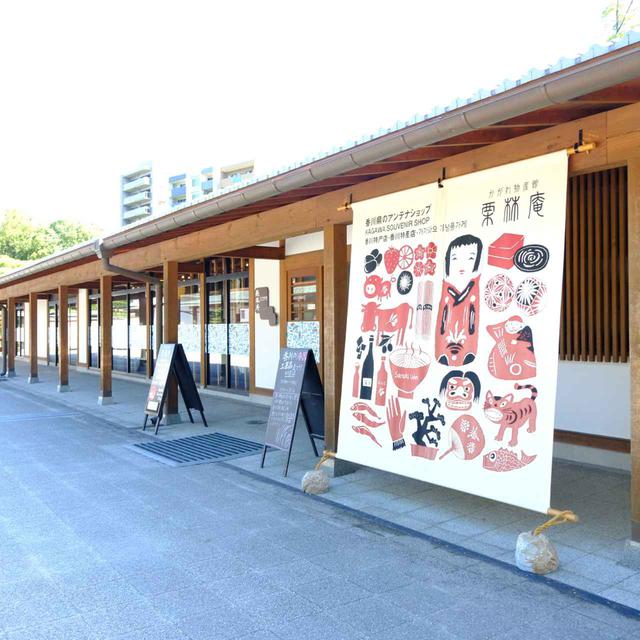 画像: 大きなのれんがかかる「かがわ物産館 栗林庵」。こののれんは、香川の伝統的工芸品「讃岐のり染」で描かれています。