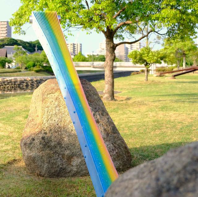 画像: 人工的な素材に「虹」という自然界の色が着色され、さらにそれを自然石が支えている。自然と人工という相対するものがひとつの作品になるという、私たちの生きる世界の縮図なのかなと解釈しました。