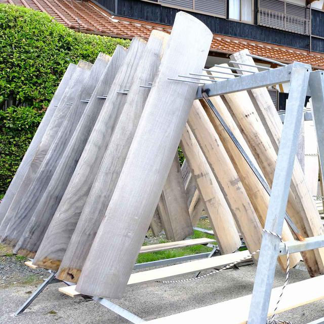 画像: 工場前には無造作に置かれた箏。こちらは天日干しで乾燥中です。琴は桐材から作られます。