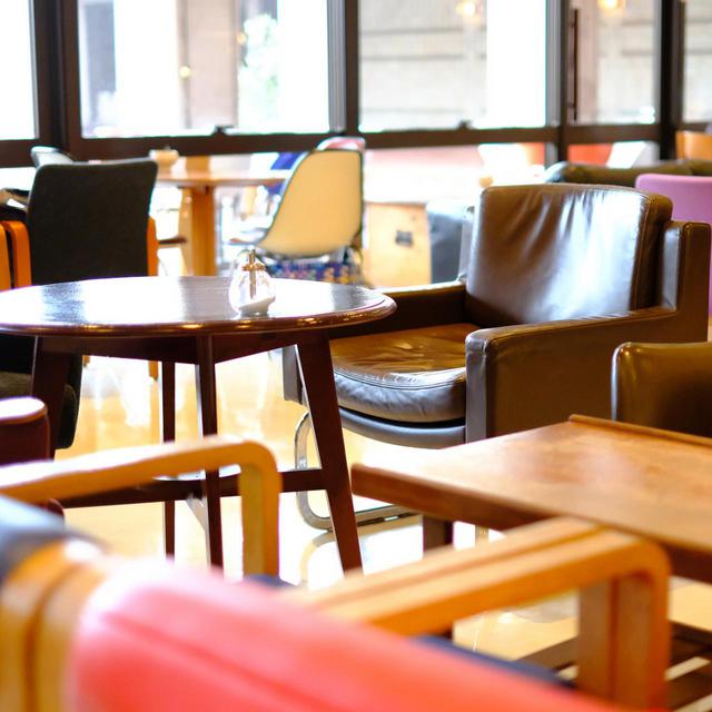 画像: カラフルな椅子がランダムに並べられた店内。おしゃれな空間で、窓からさす光で明るい雰囲気です。