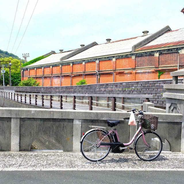 画像: 街の中を流れる宮内川とそれにかかる美名瀬橋。その向こうには旧東洋紡の赤レンガ倉庫。