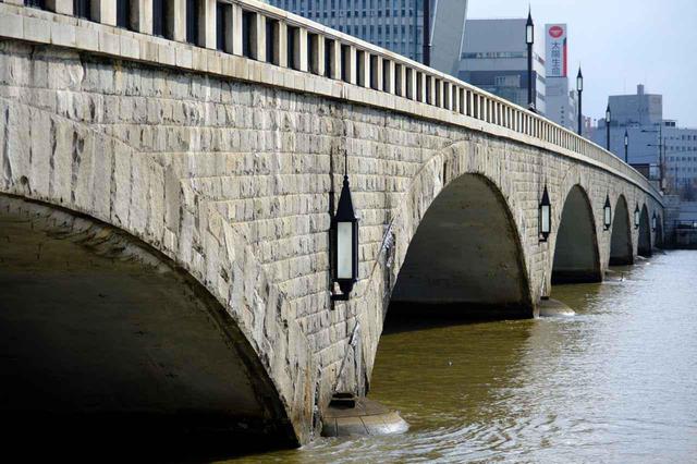 画像: 信濃川にかかる6連アーチの美しい橋です。川沿いには「やすらぎ堤」遊歩道が整備されており、橋の構造やデザイン、橋全体に施された花崗岩などをじっくり下から眺めることもできます。