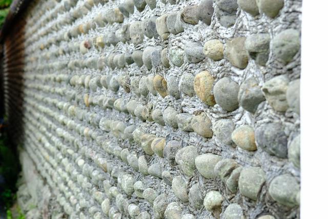 画像: 川石でしょうか、丸い自然石を積み上げた壁が続きます。